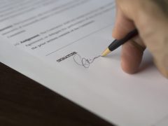 Imagen de una persona firmando un documento, la cual da acceso a los actos y requisitos relacionados con el estado civil de las personas.